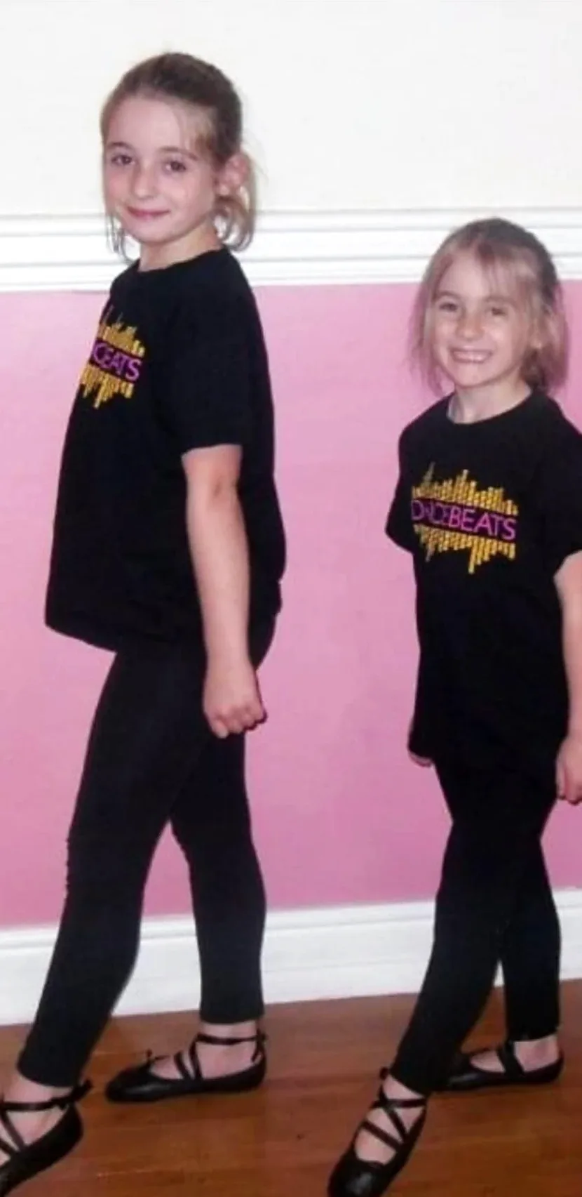 Two young Irish dancers in DanceBeats T-shirts and ghillies, smiling